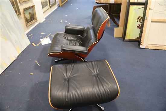 A Charles Eames cherrywood and black leather lounge chair with matching stool, made by Vitra, chair W.2ft 8in. D.2ft 8in. H.2ft 8.5in.